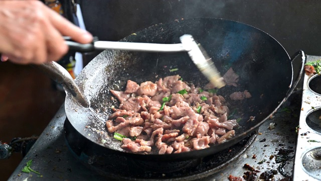 在泰国街头小吃用煎锅煮肉片视频素材