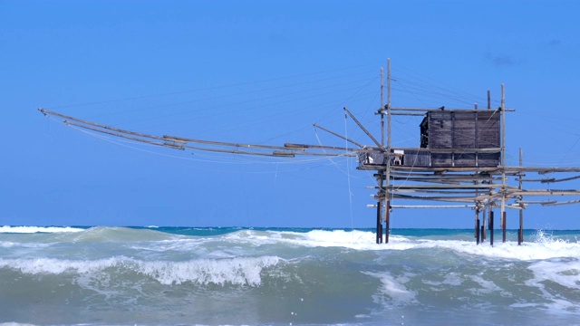 Trabocchi海岸在阿布鲁佐大浪在风大浪急的海面——制盐业Aderci Vasto储备,意大利——trabucchi老在意大利南海捕鱼机器有名视频素材