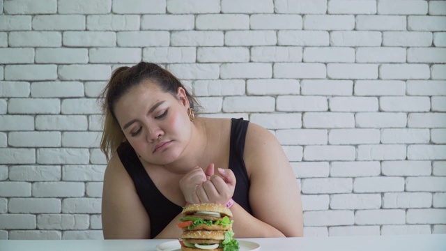 一个超重的女人想吃汉堡包视频素材