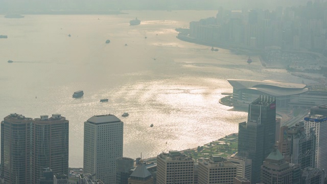 时光流逝日出与多云的维多利亚湾和建筑物基础设施在香港-维多利亚港与现代商业建筑外部地区城市视频素材