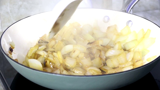 Sautéing洋葱在平底锅慢动作视频素材