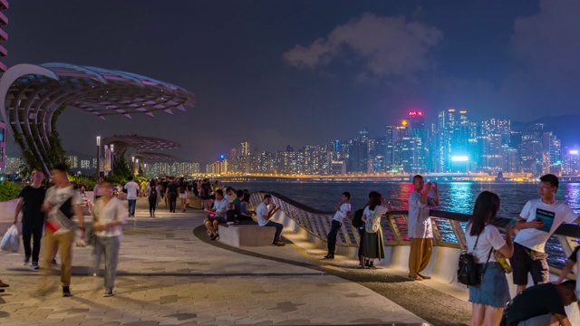 时间推移:行人行人在香港天际线市中心的夜晚，维多利亚港视频素材