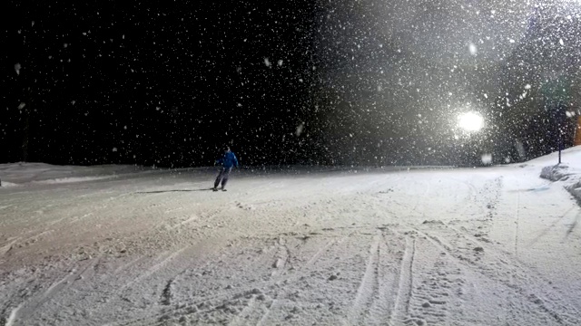 在意大利帕格内拉滑雪的雪夜，一个人骑下被照亮的斜坡视频下载