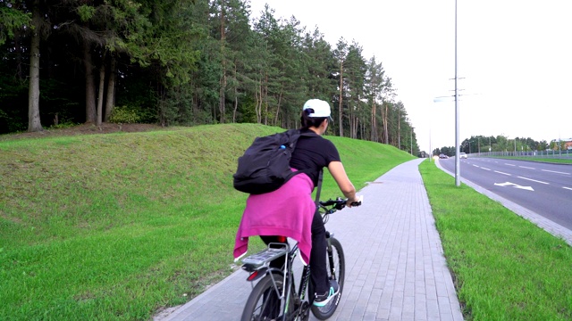 女性骑自行车者，女性在街上骑自行车，在山上举自行车，喜欢体育活动，自行车友好的城市，健康的生活方式视频素材