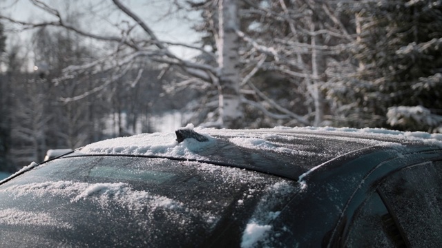 一名男子在清理车顶上的积雪视频素材