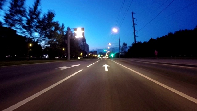 汽车沿着公园的夜市道路行驶视频素材