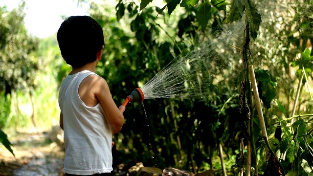 幼童在夏天在户外玩水管视频素材