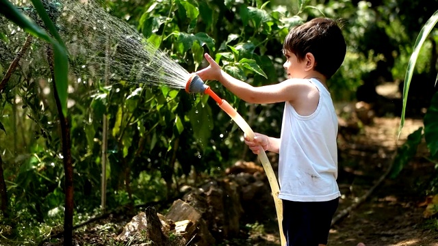 幼童在夏天在户外玩水管视频素材