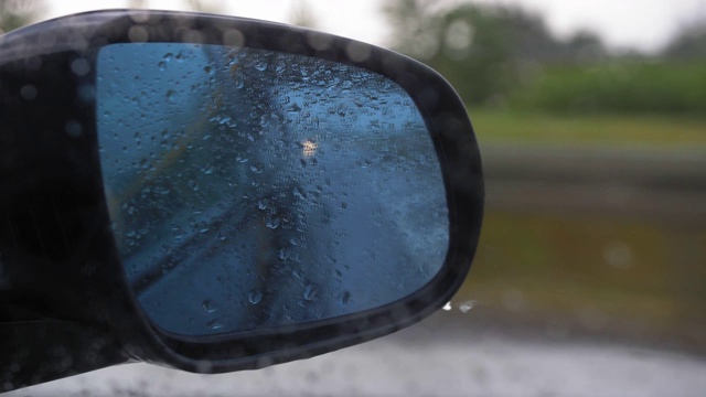 汽车在大雨中行驶的侧后视镜视频素材