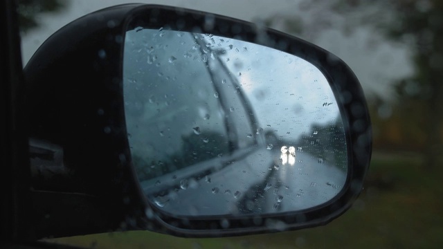 汽车在大雨中行驶的侧后视镜视频素材