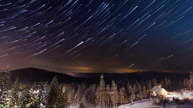 星星延时:冬天山上小房子上方移动的星星。乌克兰,喀尔巴阡山脉的视频素材