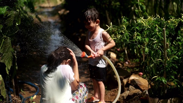 幼童在夏天在户外玩水管视频素材