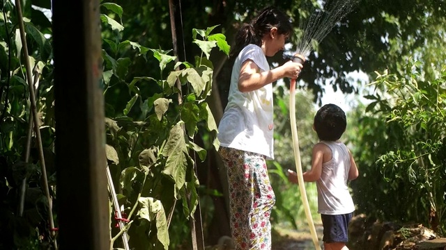 幼童在夏天在户外玩水管视频素材