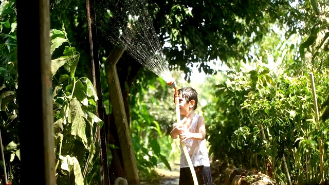 幼童在夏天在户外玩水管视频素材