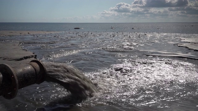 海滩上管子里流出的黑水视频素材