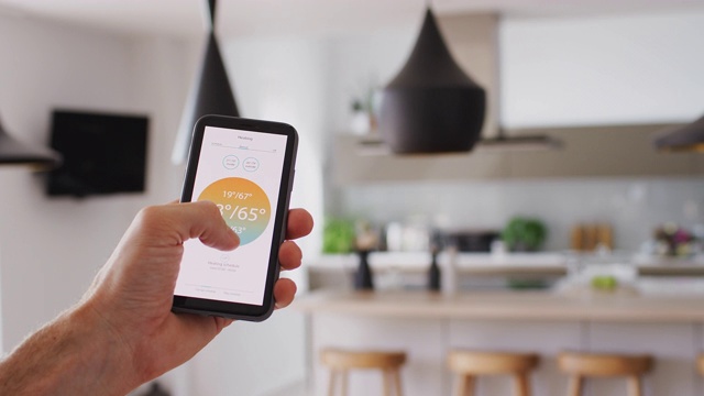 用智能手机上的App来控制室内中央供暖温度的特写视频素材