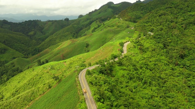 鸟瞰汽车在山间弯弯曲曲的行驶，美丽的道路适合假日旅行。视频素材