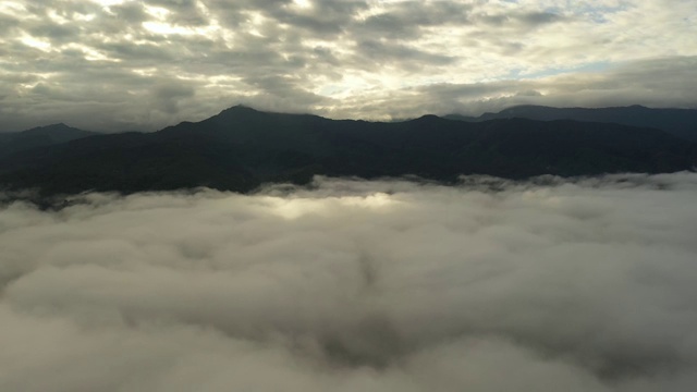 鸟瞰日出时在云中飞翔的山上视频素材