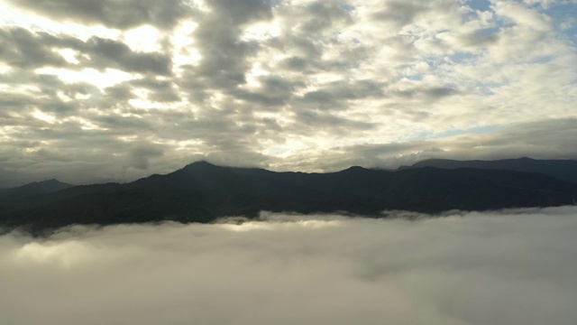 鸟瞰日出时在云中飞翔的山上视频素材