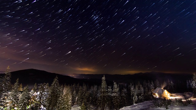 星星延时:冬天山上小房子上方移动的星星。乌克兰,喀尔巴阡山脉的视频素材