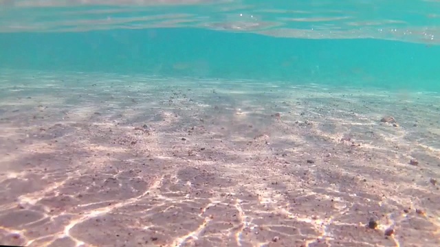 在一个晴朗的日子里，沙滩附近的光波水下，红海，沙底。慢动作标准动作。视频下载