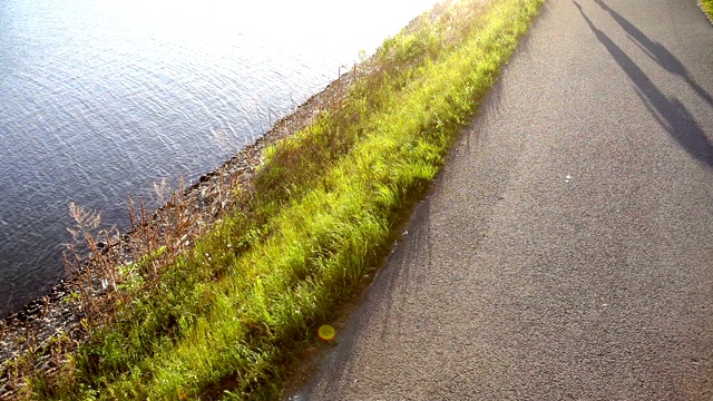 两名跑步者(一男一女)清晨在水库附近慢跑视频素材