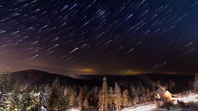 星星延时:冬天山上小房子上方移动的星星。乌克兰,喀尔巴阡山脉的视频素材