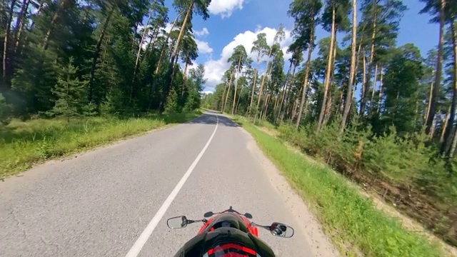 摩托车手沿着森林道路行驶的俯视图。公路上的摩托车。视频素材