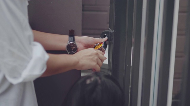 女人用钥匙打开大门。使用钥匙和锁门的人员。房地产安全视频素材