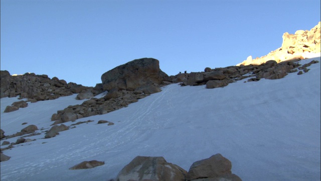 徒步旅行者攀登一座岩石山。视频素材