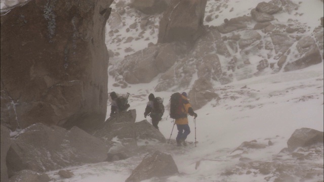 一队徒步旅行者在雪山中行走。视频素材