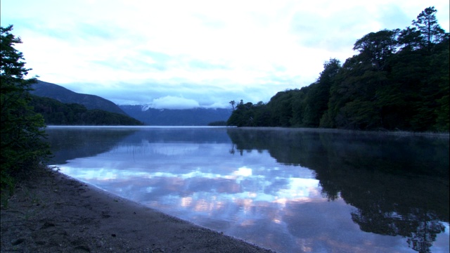 一个湖映照着周围的小山。视频素材