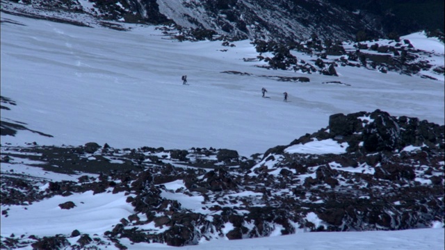 徒步旅行者走下雪坡。视频素材