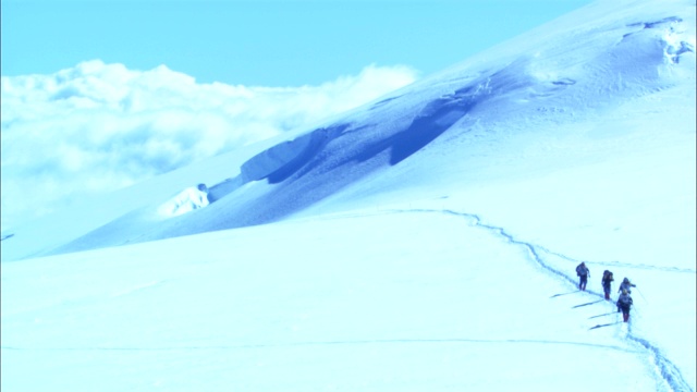 徒步旅行者沿着雪道前行。视频素材