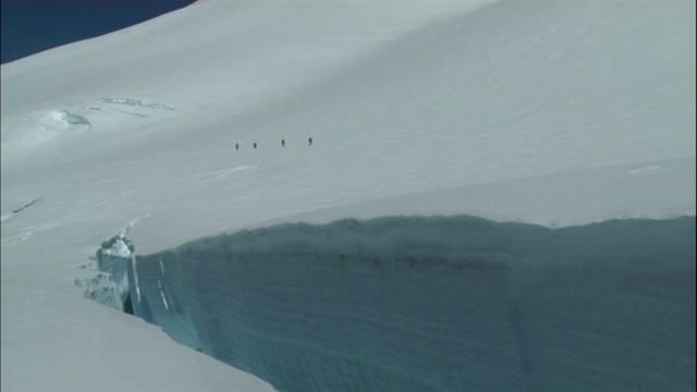 远处的一队徒步旅行者正穿越雪地。视频素材