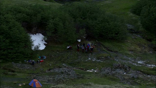 徒步旅行者准备离开一个山地营地。视频素材