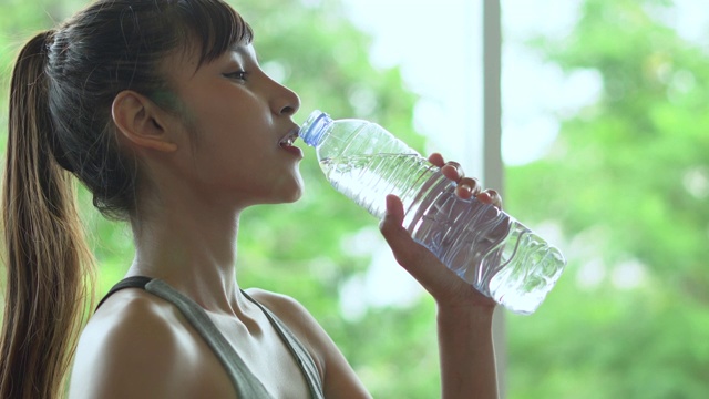 年轻健康的女人喝着塑料瓶里的水视频素材