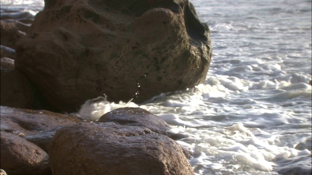 海浪冲击着多岩石的海滩。视频素材