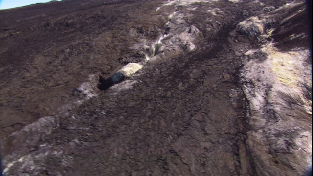 一架直升机飞过一片火山景观。视频素材