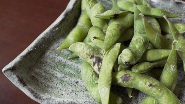 煮熟的绿色有机毛豆与盐翻，日本食物视频素材