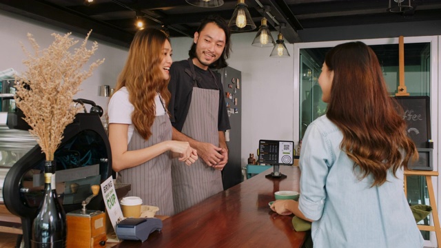 年轻的亚洲咖啡师男人和女人与亚洲女性顾客与幸福的柜台在咖啡馆咖啡馆视频素材