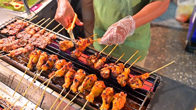 近距离的手翻肉在烧烤的街头食品，泰国视频素材