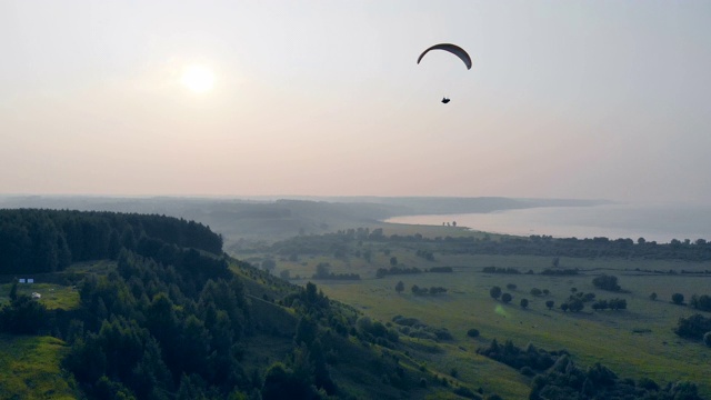 一个人在空中用滑翔伞飞行。滑翔伞在天空。视频素材