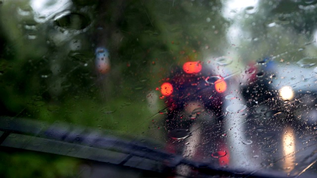 下雨的时候，开车在路上，雨点滴落在玻璃窗上视频素材