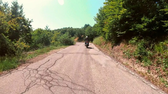 骑摩托车的人在山区的乡村公路上视频素材