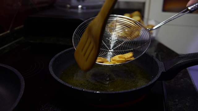 4K薯条烹饪。土豆放入滚烫的油中。餐馆里的快餐视频素材