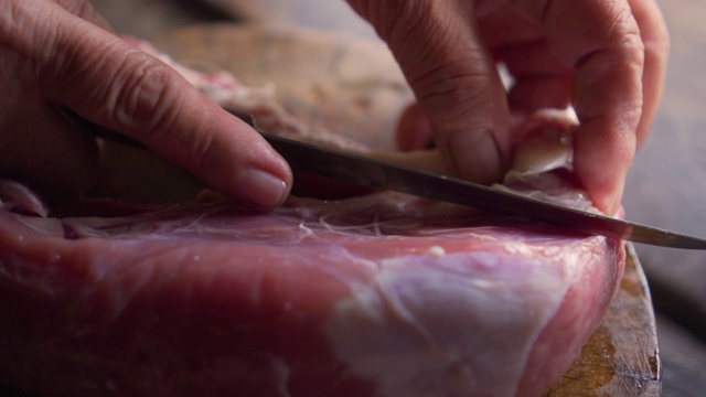 老太太用手切猪肉。准备下一步的烹饪。视频素材