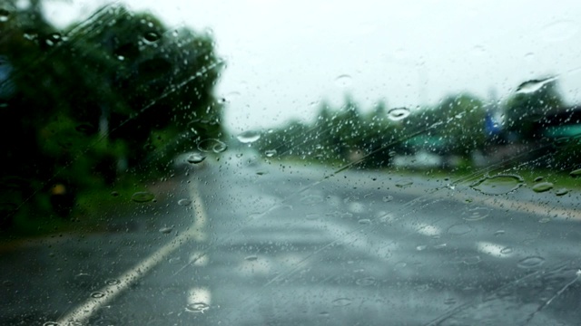 下雨的时候，开车在路上，雨点滴落在玻璃窗上视频素材