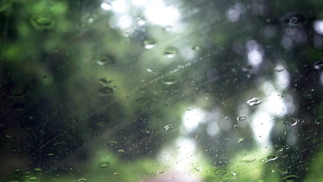 下雨的时候，开车在路上，雨点滴落在玻璃窗上视频素材