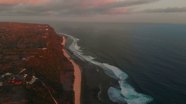 沙滩和海洋的鸟瞰图，温暖的日落。Uluwatu,巴厘岛视频素材